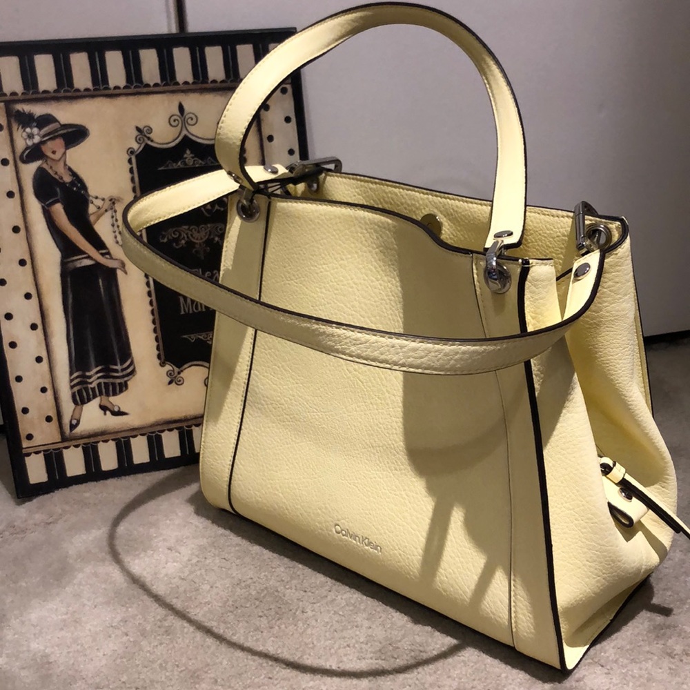 Calvin Klein handbag has a snap generous pocket on the outside and three cmpts